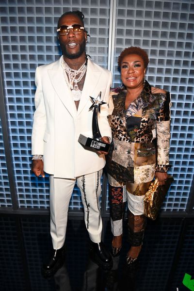 Burna Boy with the award accompanied by his mum