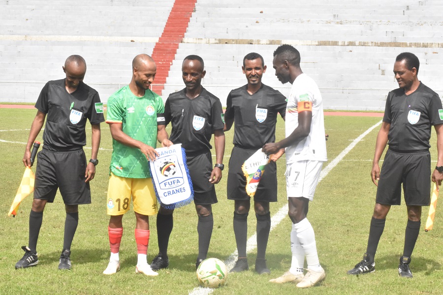 Shemeles Bekele exchange badges with Emmanuel Arnold Okwi as the referees keep a keen eye