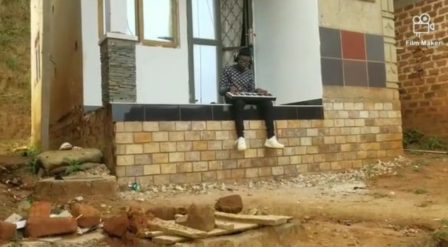 Aganaga seated in front of his house