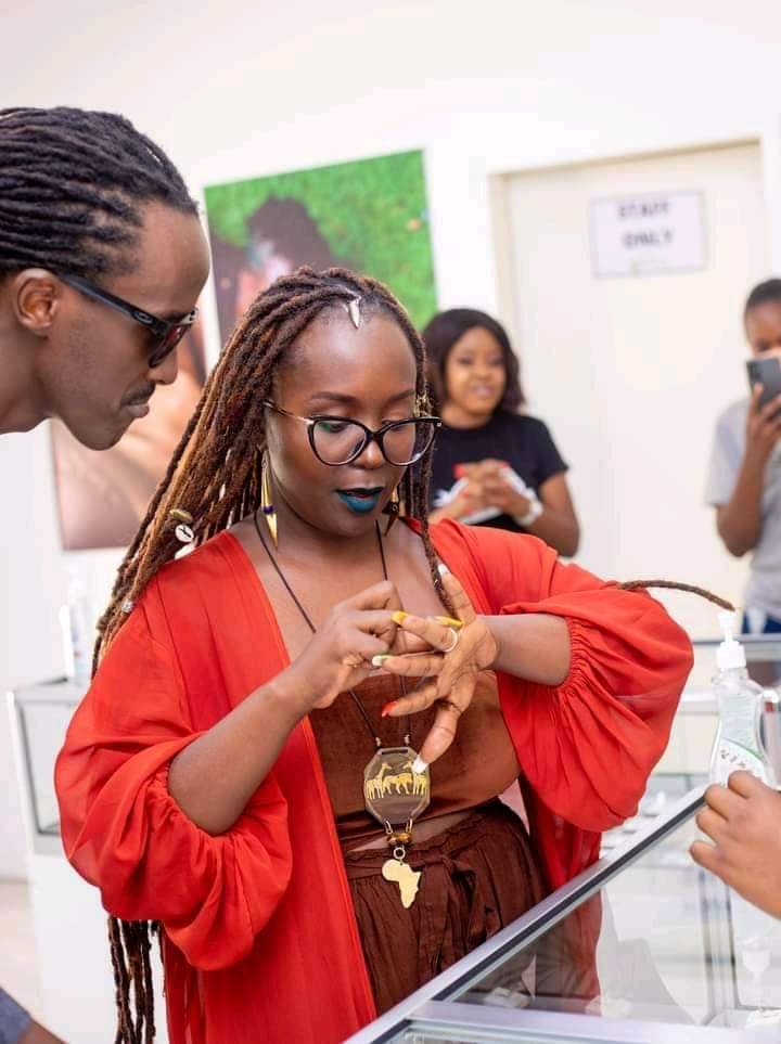 Kansiime trying on a ring as Skylanta looks on