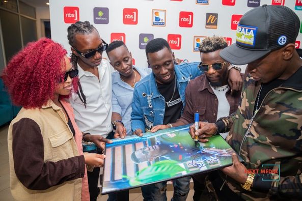 Jose Chameleone signing his portrait as the 'After 5' crew looks on