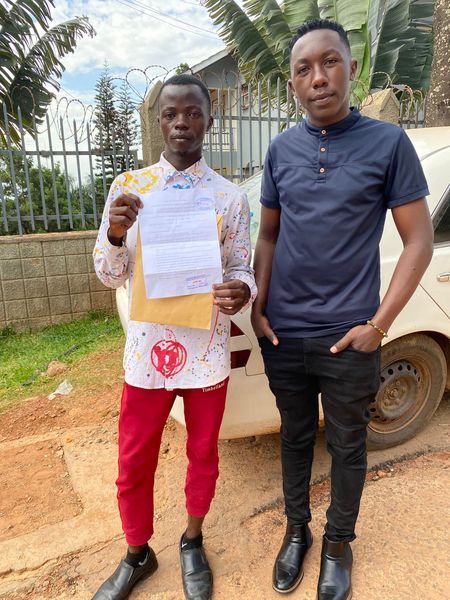 Simple K with NBS TV presenter, Kayz showing off court letter