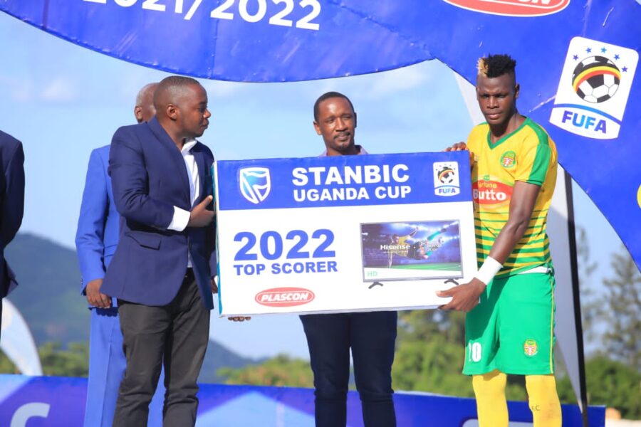 Top scorer Karim Ndugwa receives a set of TV from Stanbic Bank Commerical Manager, Anthony Namanya.