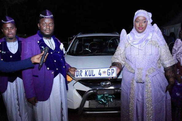 Akram Gumisiriza and Kluthum showing off a car